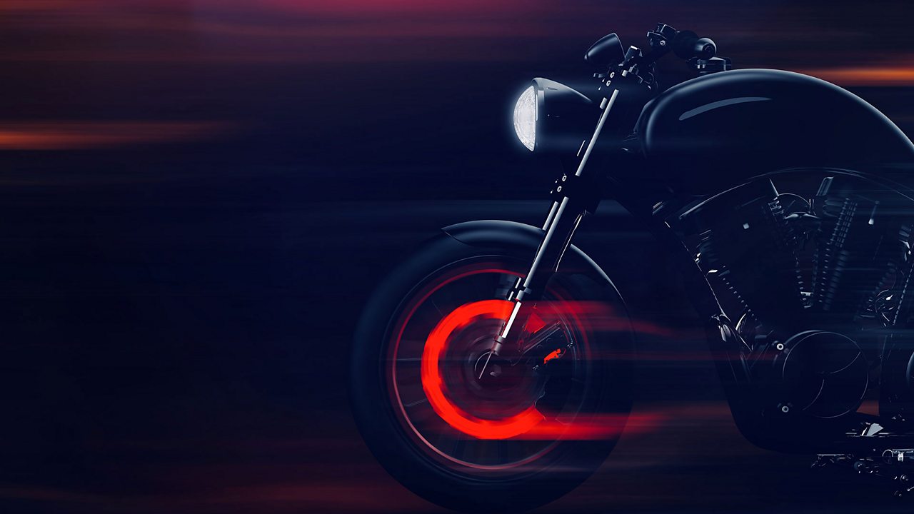 The brakes of a motorbike glow red. During braking, energy is transferred from the kinetic store of this motorbike to the thermal store in the brakes, causing the front brake discs to get red hot.