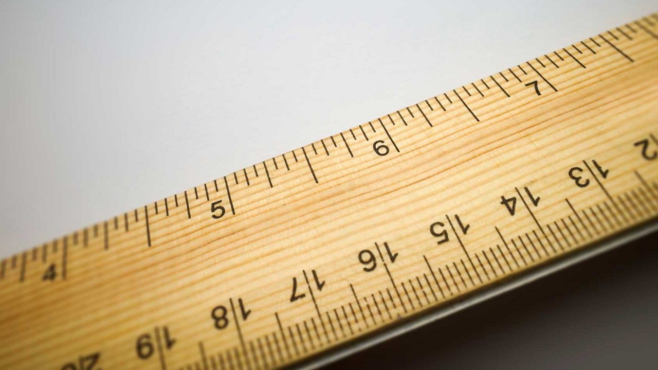 Close up of a ruler, with inches on one side and centimetres on the other side.