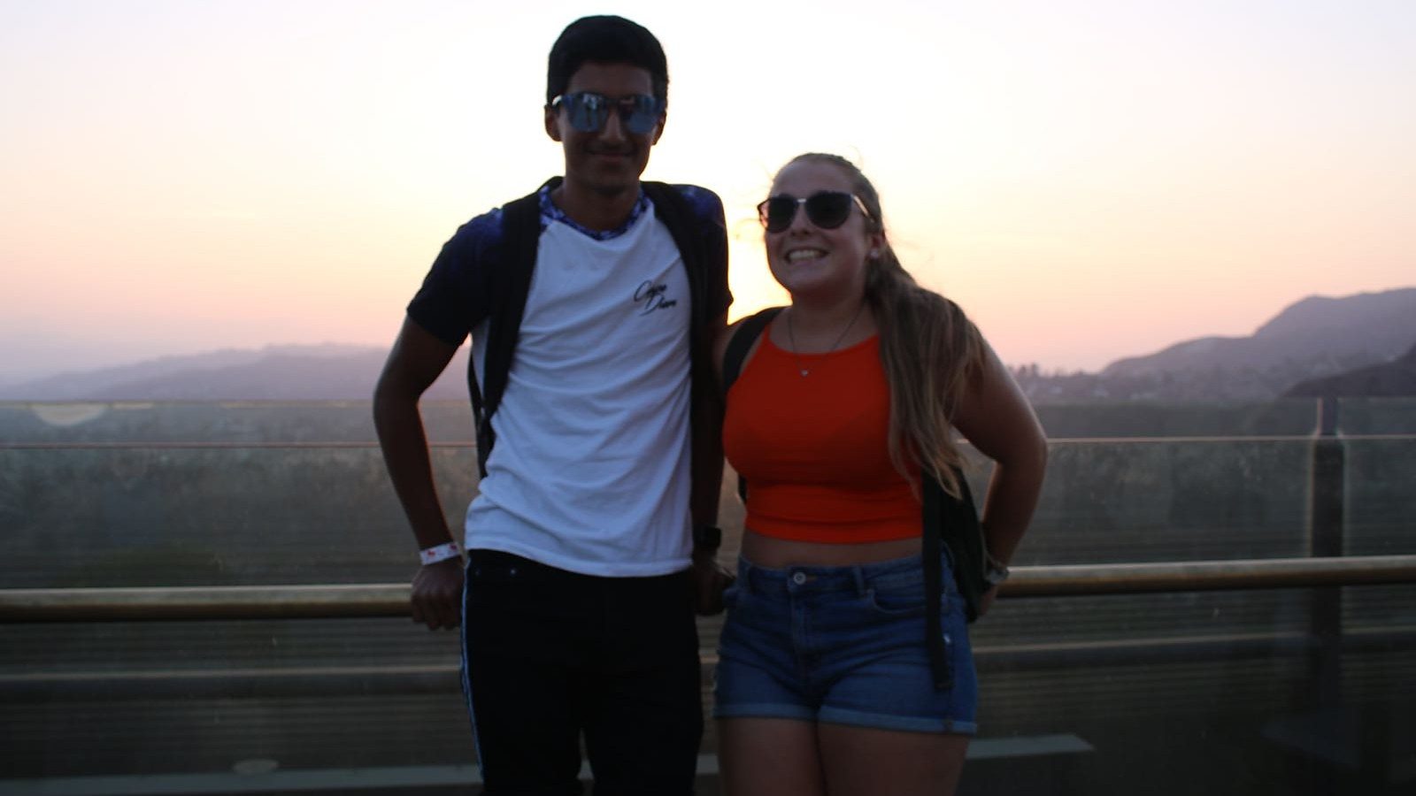 Image of Lucy and Arun posing for a photo with a beautiful mountain view behind them