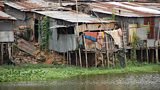 Shanties on the edge of a deep lake in a poor area of Dhaka city
