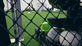 An automatic football drills machine sat on the ground at an indoor training centre.
