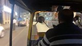 A man driving a tuk tuk.