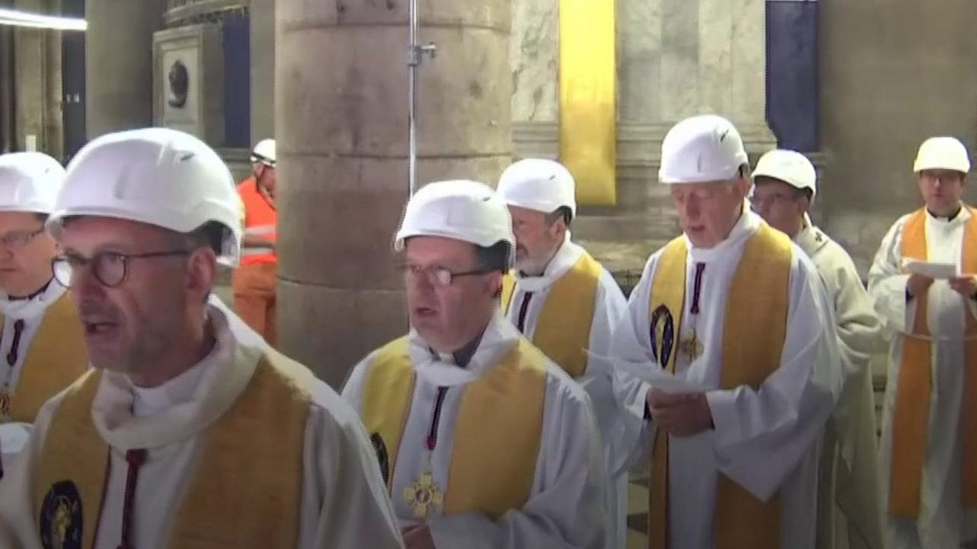 Priests wear hard hats at Notre-Dame 
