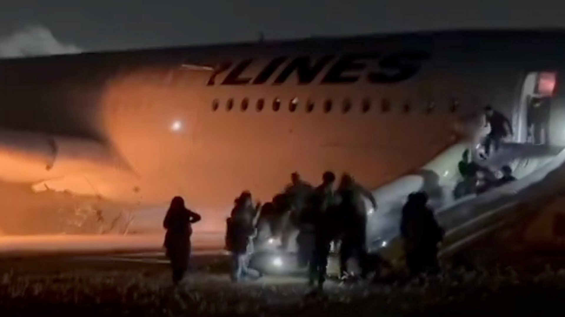 Passengers clamber down emergency slide after Japan plane fire