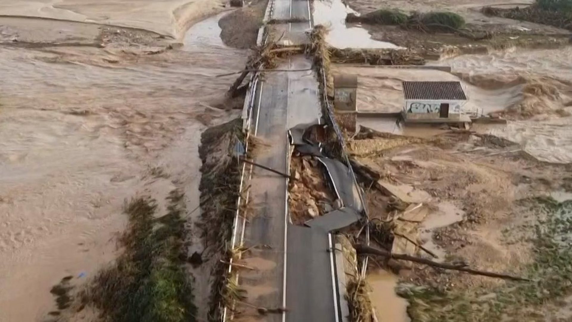 Floodwaters surge around a badly damaged road in El Pontón, a village in the Valencia region