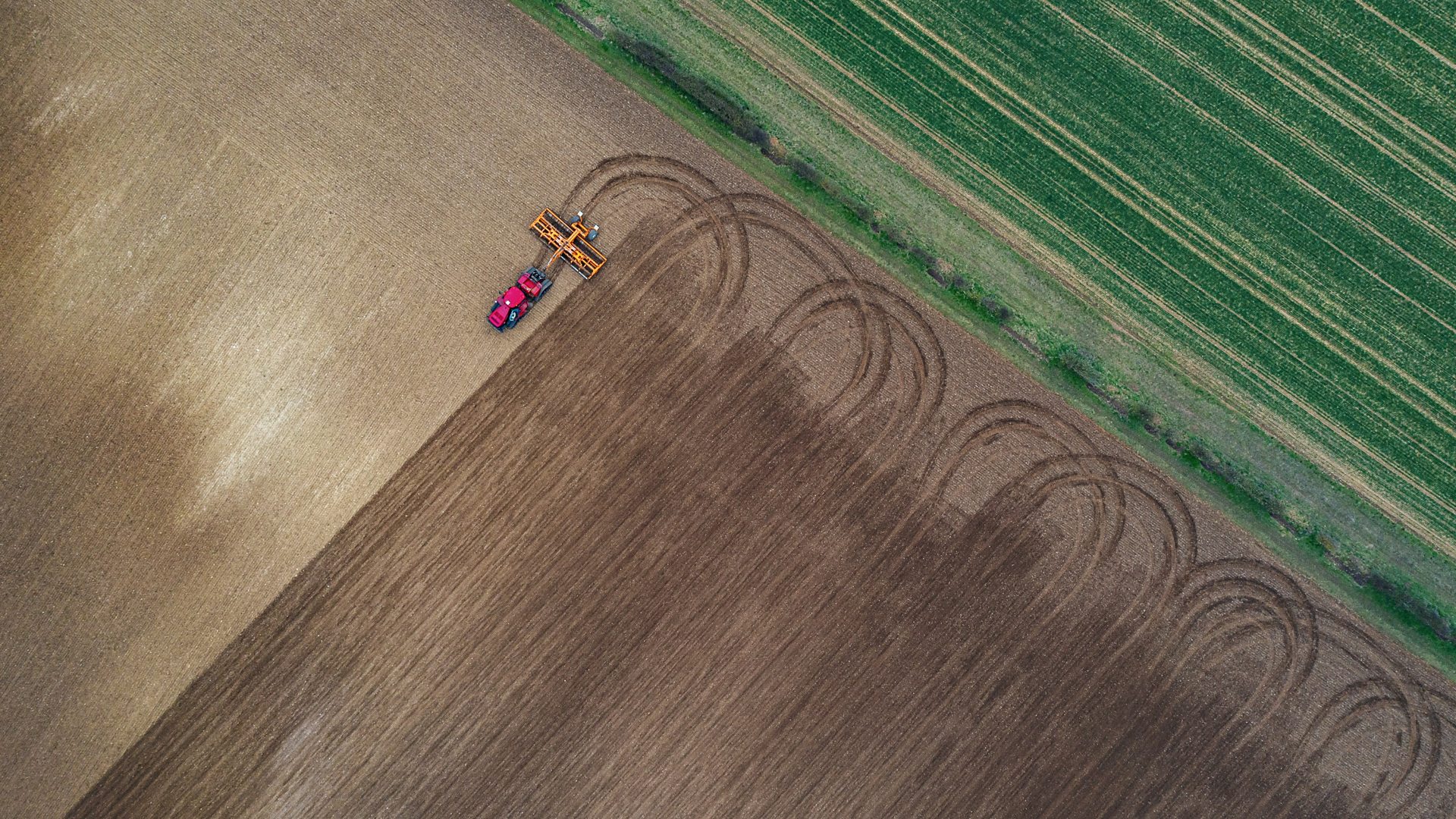 Drone view of tractor ploughing a field (Credit: Justin Paget via Getty Images)