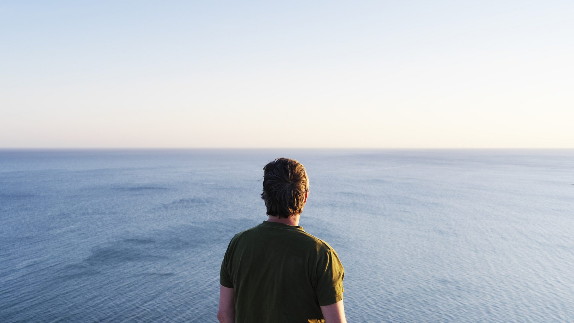 Man overlooking the sea from cliff top (Credit: Gary Yeowell via Getty Images)