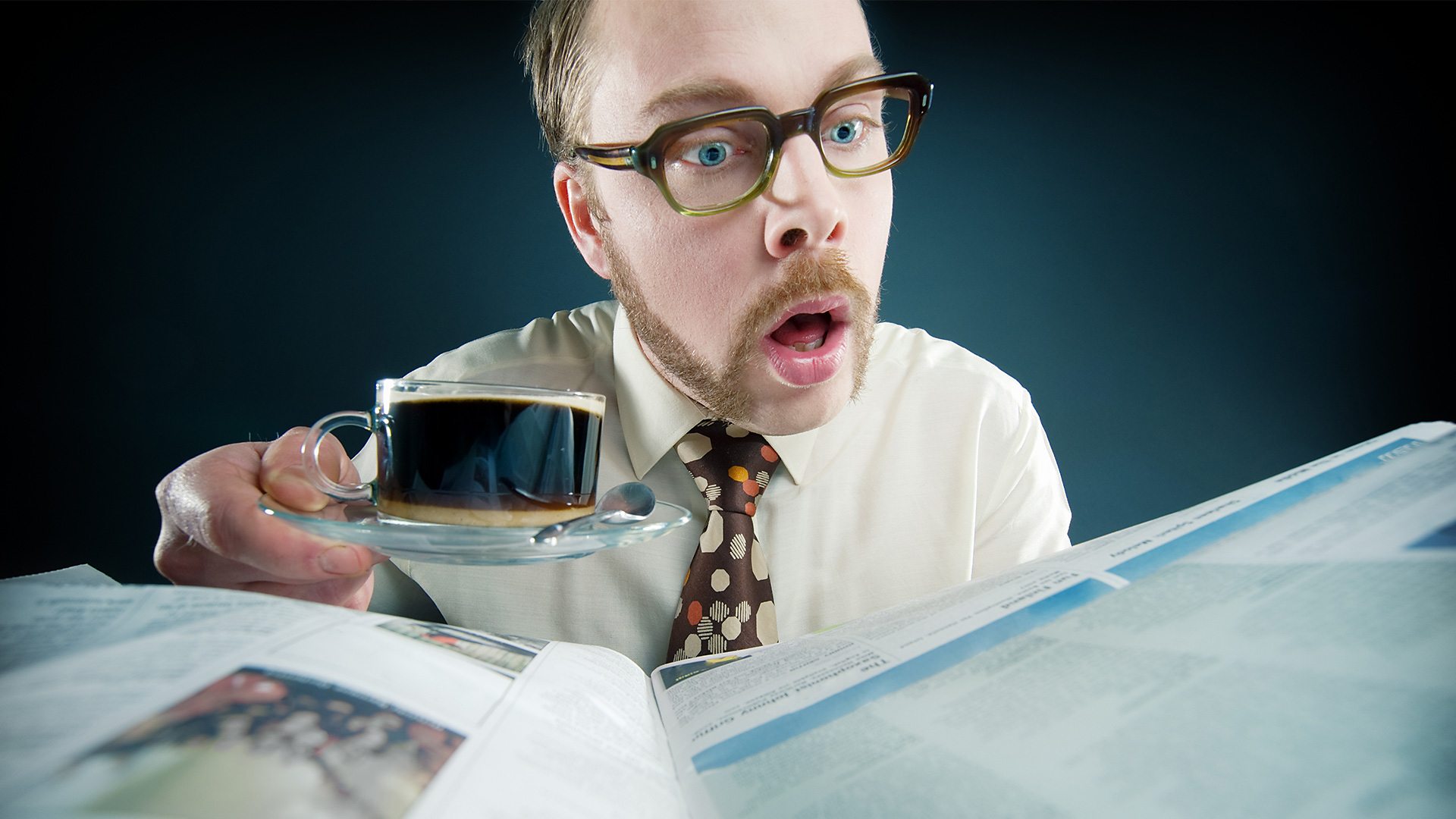Man reading funny British headlines