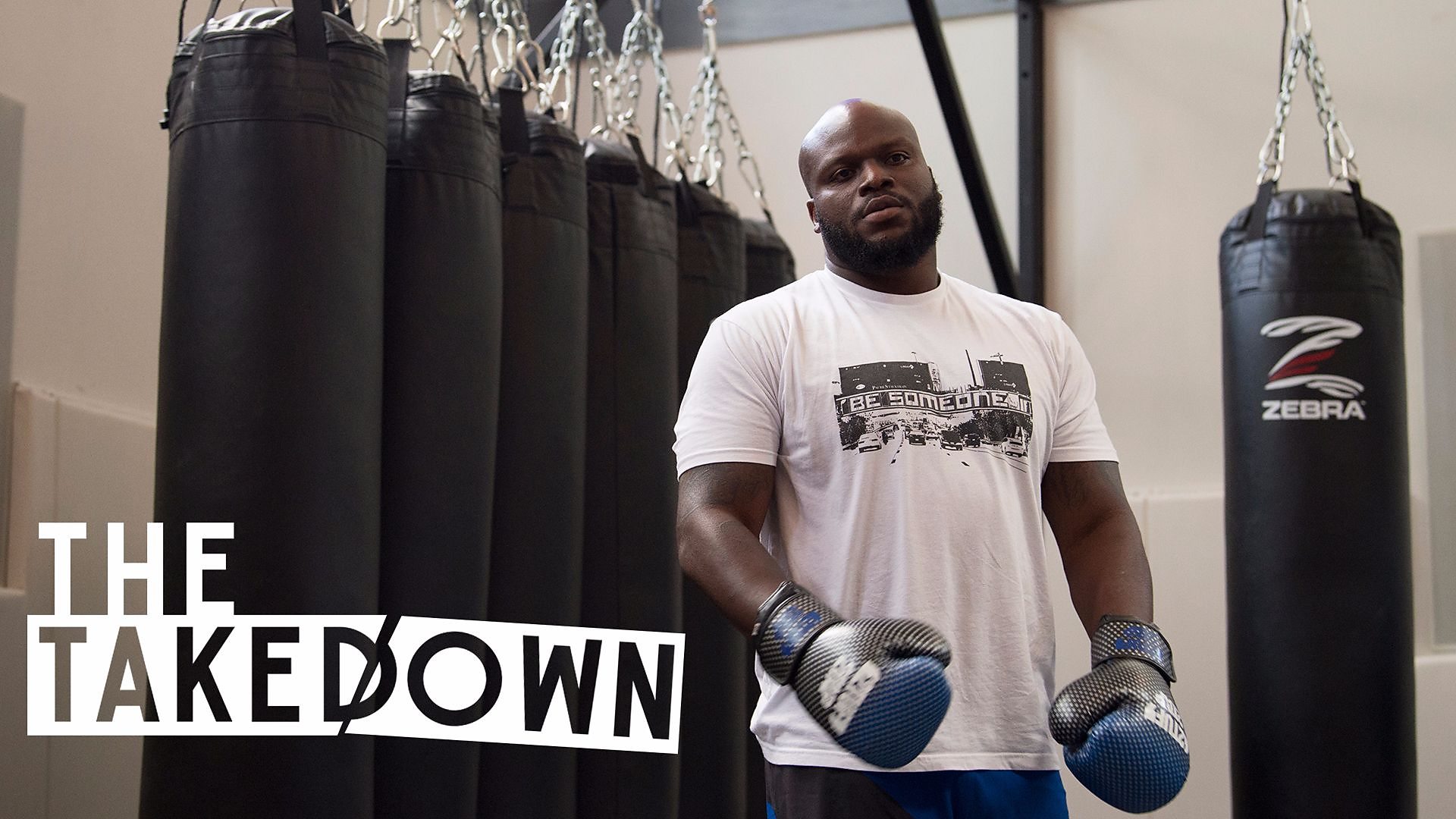 Derrick Lewis poses next to gym equipment