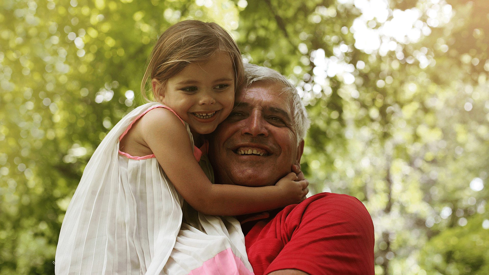Young girl hugging old man