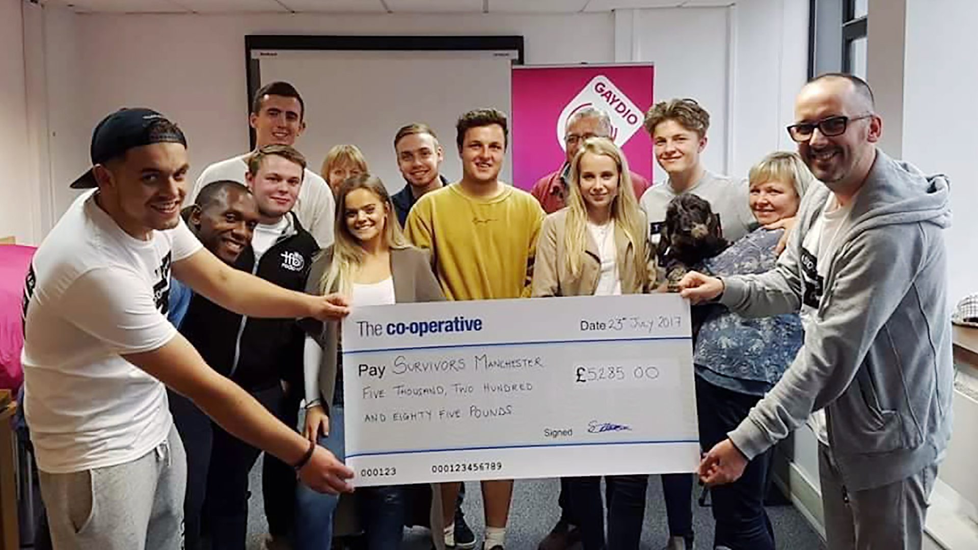 Members of Survivors Manchester holding a cheque for money they've raised