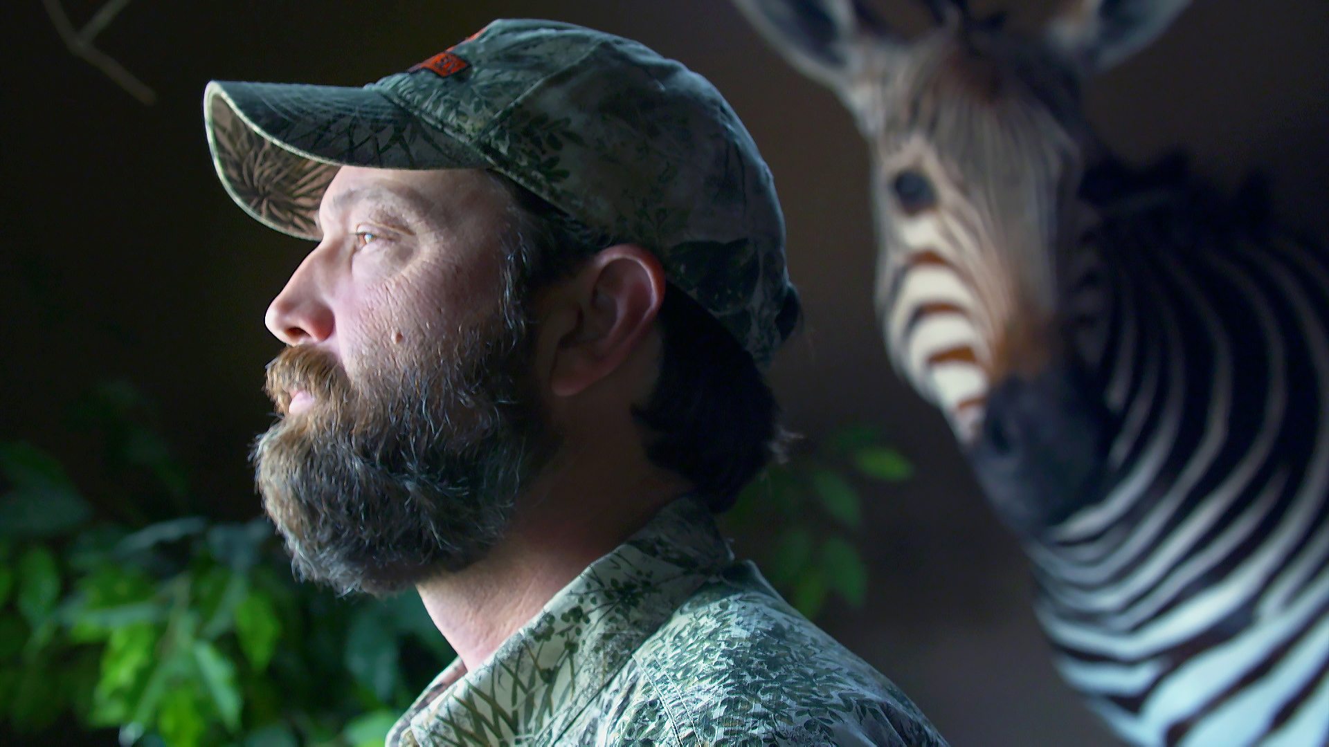 Philip Glass with a mounted zebra head in the background