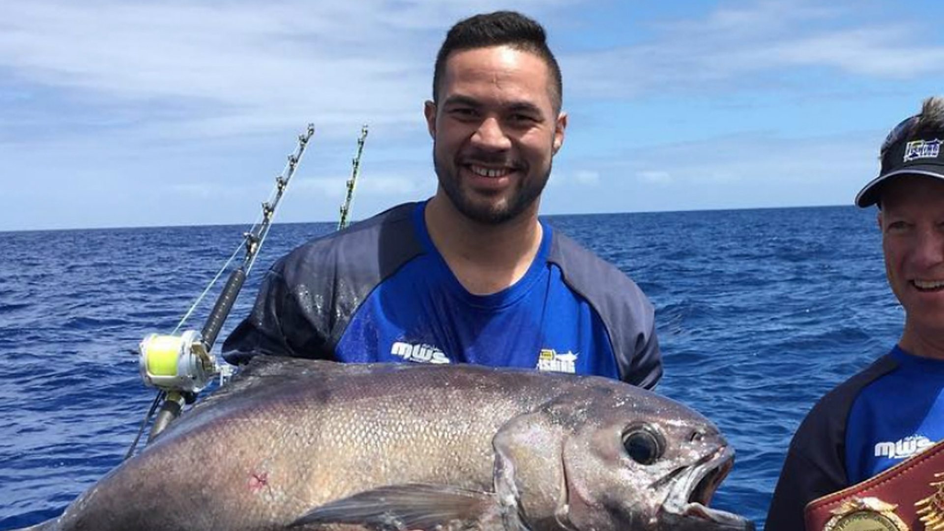Joseph Parker holding a large fish on a boat