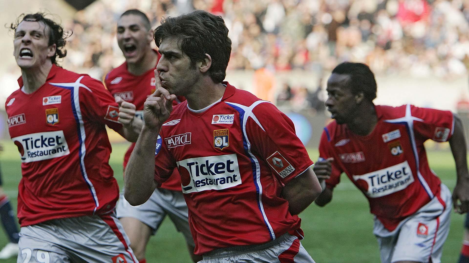 Juninho celebrates with his Lyon team-mates, including Karim Benzema