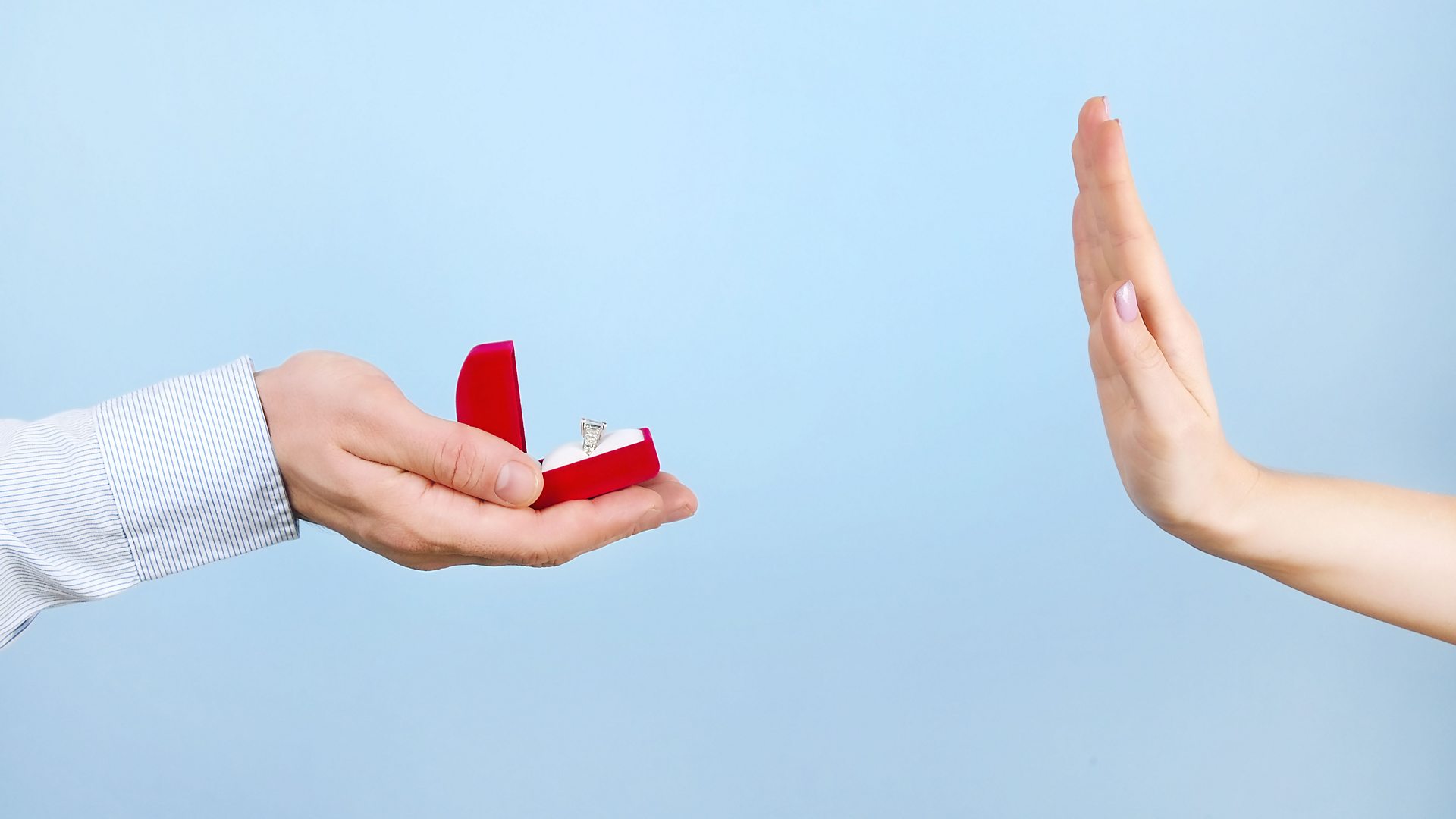 Picture of a hand with engagement ring and someone else turning it down