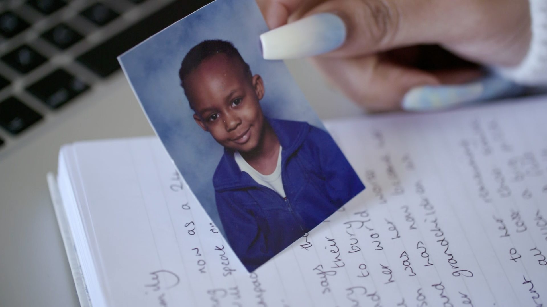 A shot of Chanell holding a primary school photo of her brother Daniel