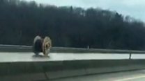 Giant wire spool rolls down motorway