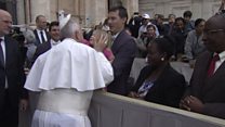 Young girl removes Pope's hat