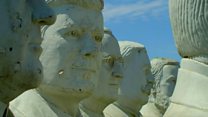 Giant presidents' statues crumble in field