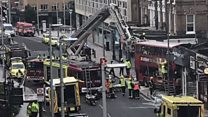 Two trapped after bus crashes into London shop