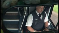 Driver on phone at wheel of holiday coach