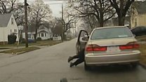 Terrifying moment cop is dragged by car
