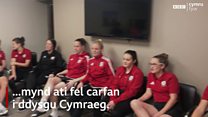 Mae tîm merched Cymru'n dysgu Cymraeg
