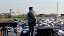 A drive-in concert in an airport car park