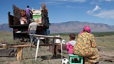 Borbak Dongak waits with her grandaughter Aldyn-Kys, her sons unload the family yurt