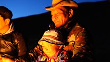 Sukhbaatar and his son Sumya warm themselves by the fire out in the Steppe. The 2010 winter wiped out all of Sukhbaatar's herd.