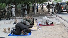 The mayor prays with Somali soldiers at a disputed checkpoint