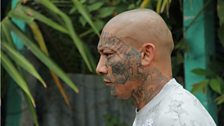 A Mara Salvatrucha member shows his facial tattoos