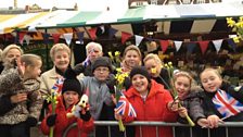 Excited crowds wait with flowers for William and Kate.