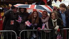 Crowds using their flag to keep dry outside Guildhall.