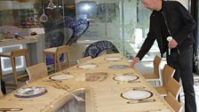 Dom inspects the dining table in the kitchen.