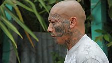 A Mara Salvatrucha member shows his facial tattoos