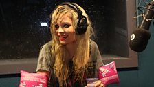 Nina Nesbitt wearing pink arm bands and drenched head to toe