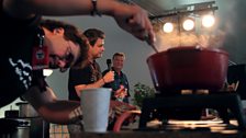 Steve Riley and the Mamou Playboys. Kevin (drummer and best cook in the band) stirs while Steve talks to host Roger de Wolf.