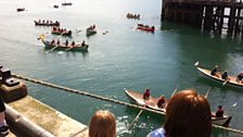 Crowds gather to watch the skiffs row past