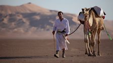 Ben Fogle walking  with  his camel.