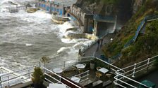 Waves crash over Tinside pool