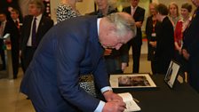 HRH The Prince of Wales signs the remembrance book for Komla Dumor