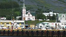 View of Husavik, lupins growing on the hillside behind.