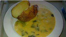 Jacket potato with leeks in a cheese sauce.