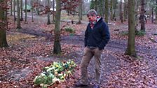 Tom looking at a recent grave at the Sustainability Centre, marked with fresh flowers.