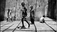 Street kids play in a derelict Monrovia builing. Despite the social breakdown, football still brings youths together.