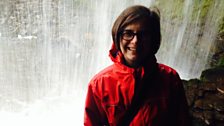 Felicity standing behind the waterfall at Sgwd yr Eira, in Brecon Beacons Waterfall Country