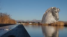 The Kelpies standing alongside the Forth and Clyde Canal