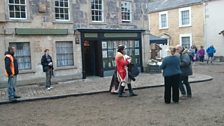 Onlookers watch the cast in their costumes