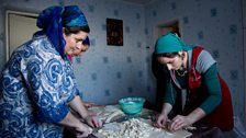 Zora and Aina cutting dough into strips, which they will then boil to make the dish called Jijig Galnish.